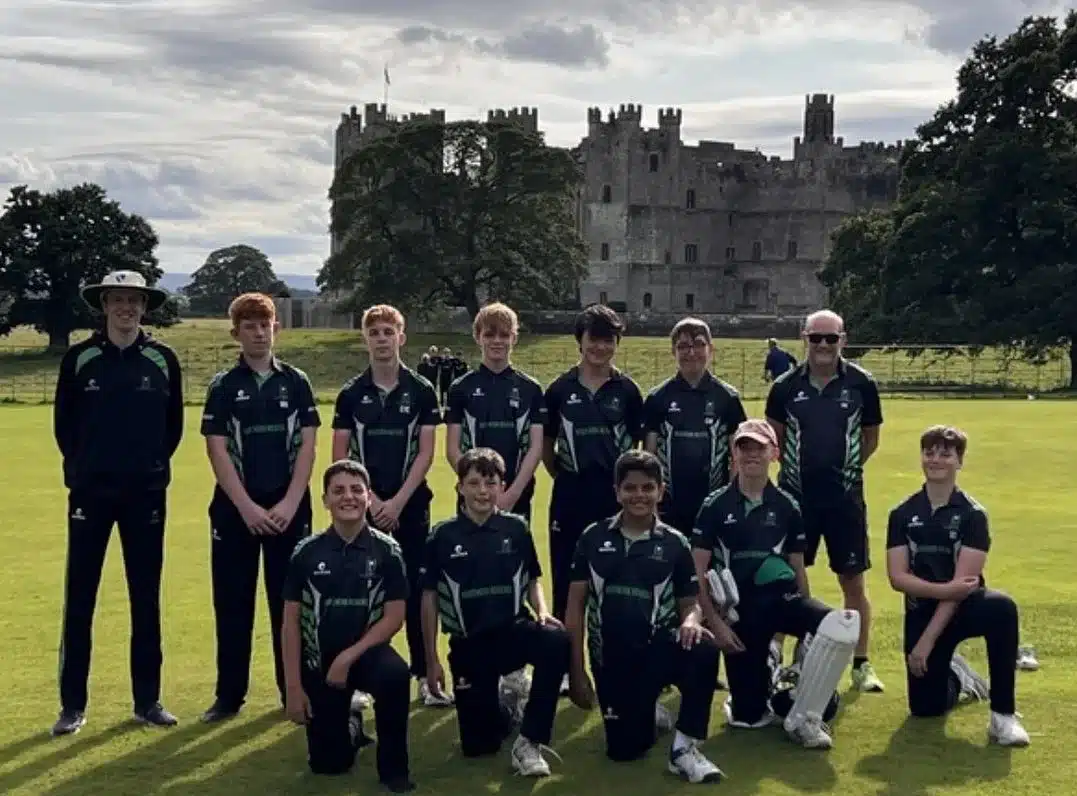 Cricket team posing in front of a castle during residential festival